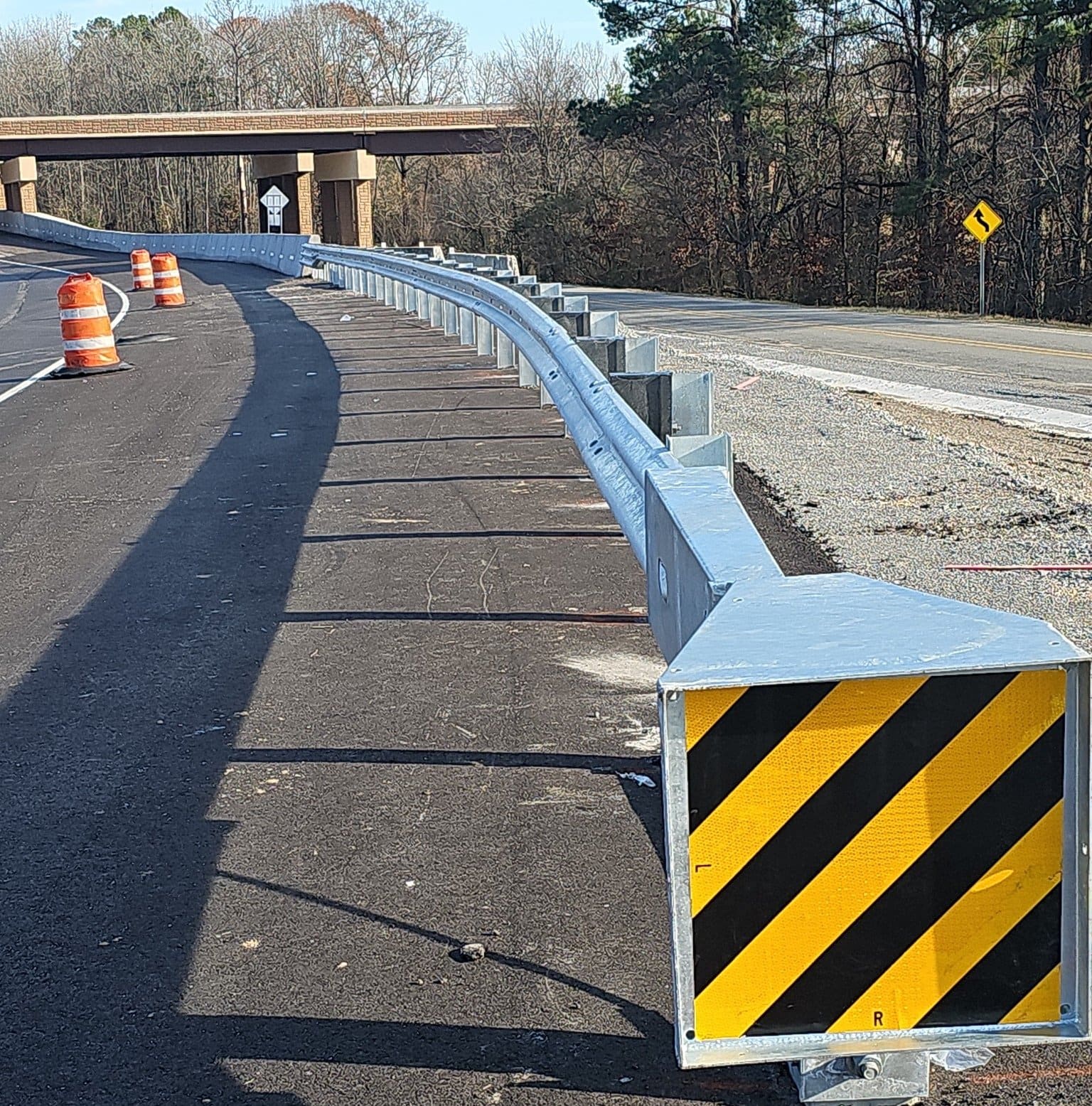 Guardrail end terminal with black-and-yellow object marker at a highway work zone